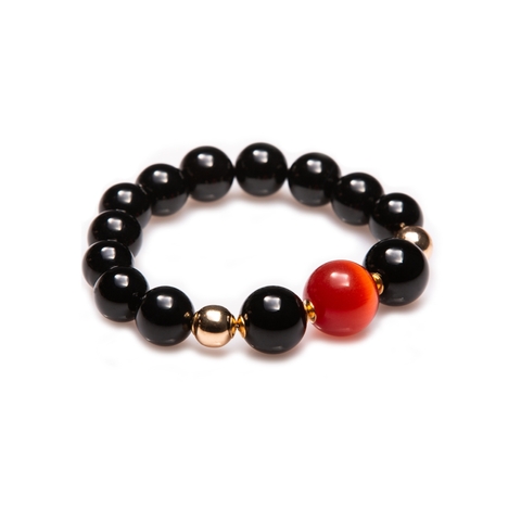 A bracelet with black agates and a beautiful orange stone.