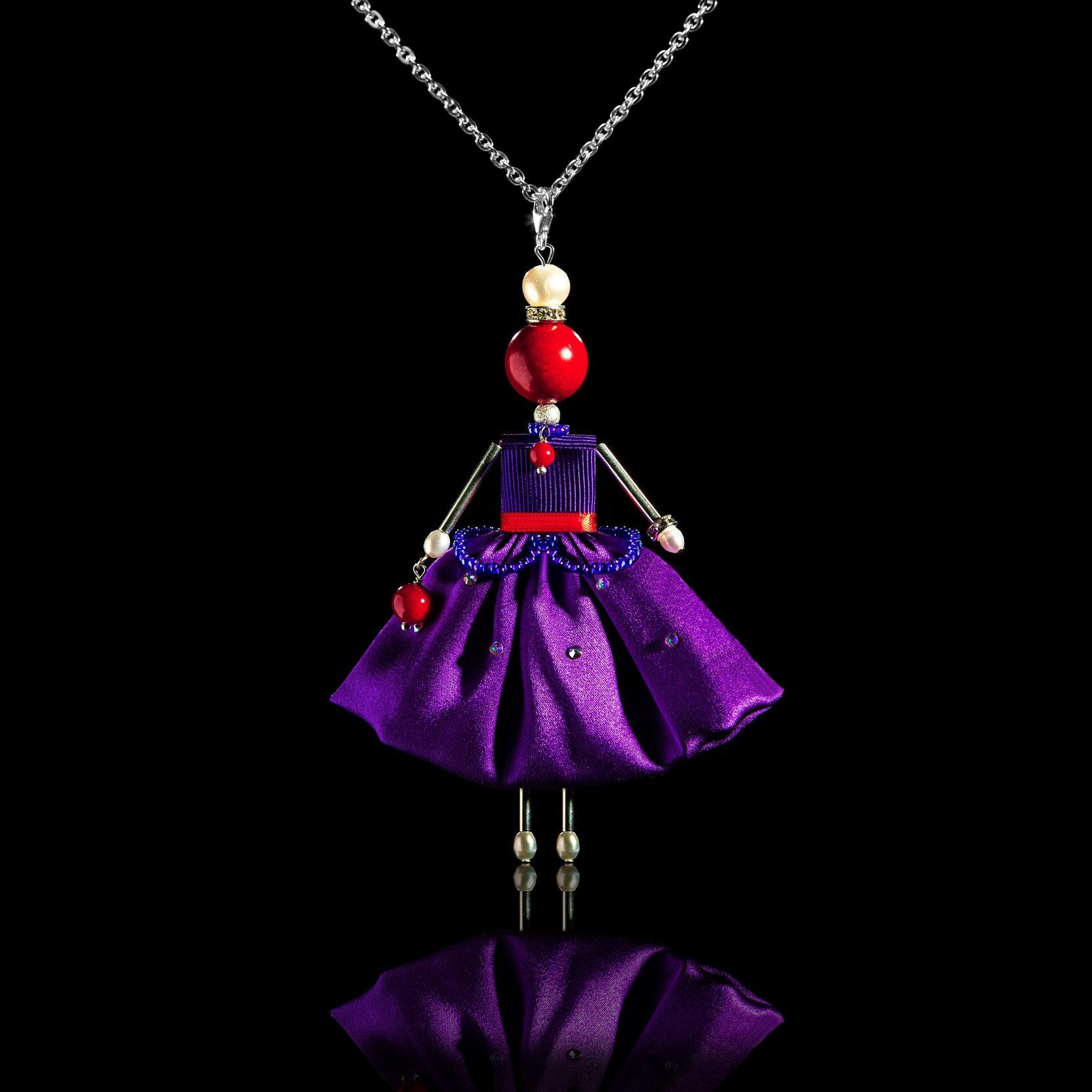 Enchanting pendant doll in a purple silk skirt.