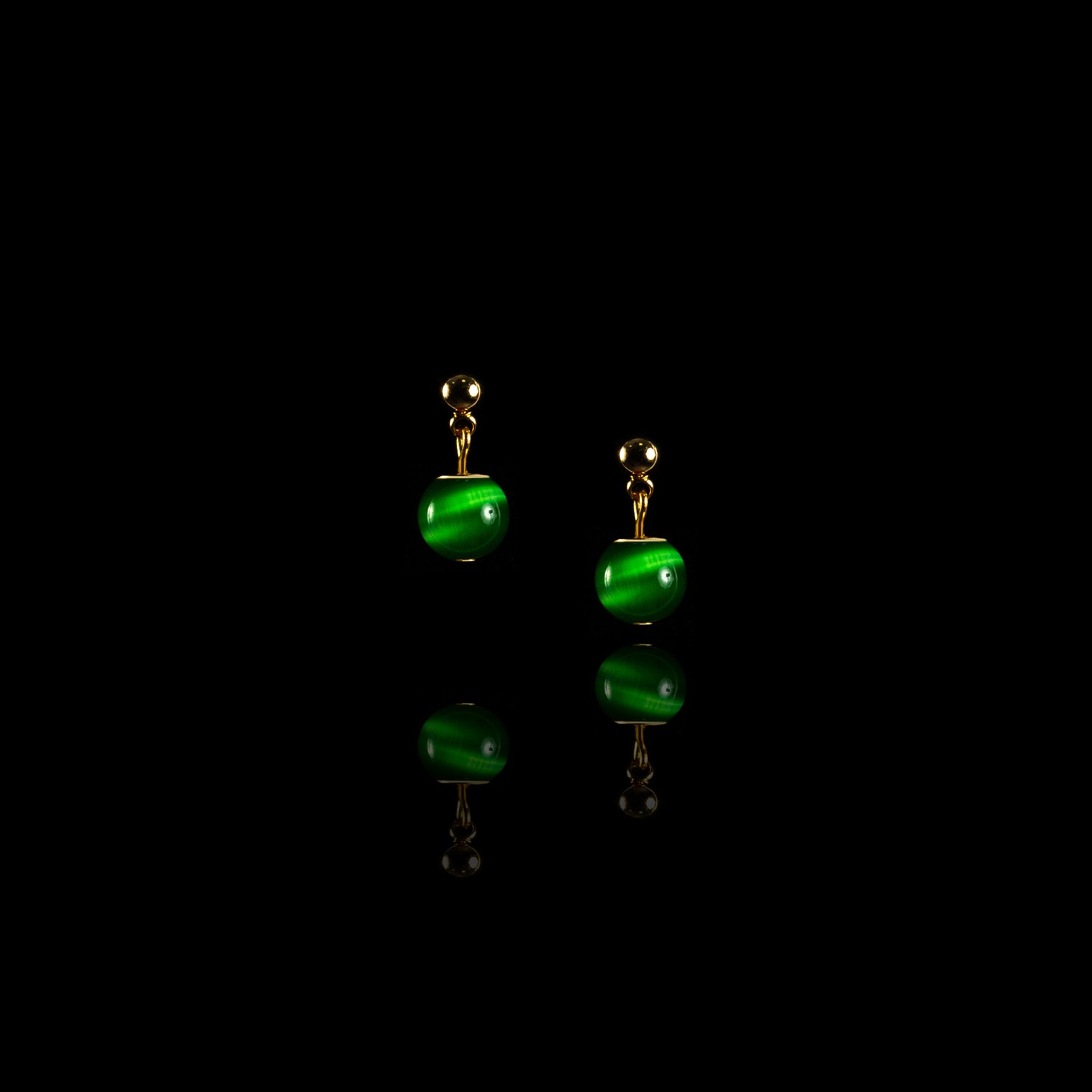 Маленькі сережки-гвоздики з зеленим каменем.