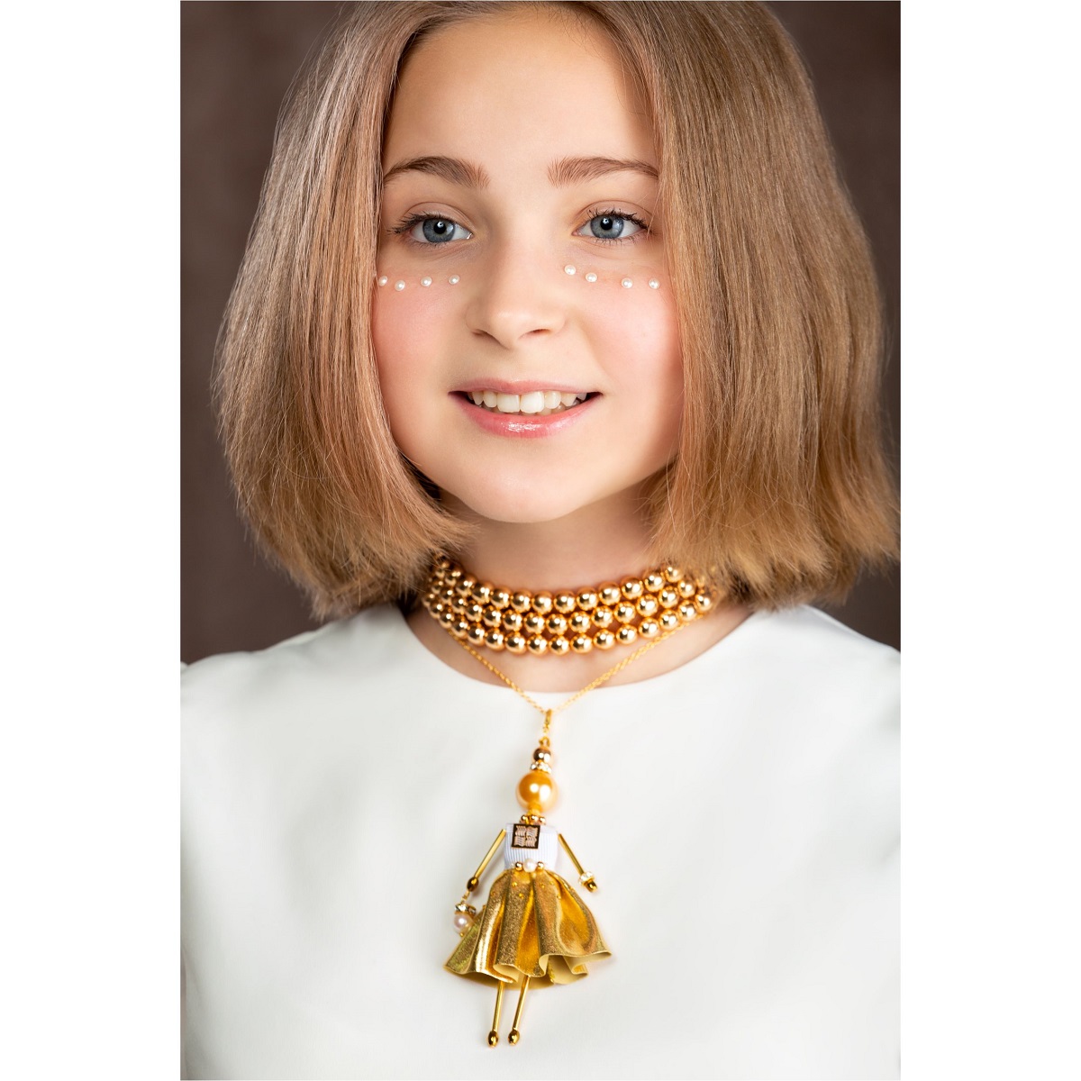 Ювелірна лялька-підвіска із золотою перлиною, гематитом, Swarovski® та золотистим вбранням — незвичайна прикраса SARANA®