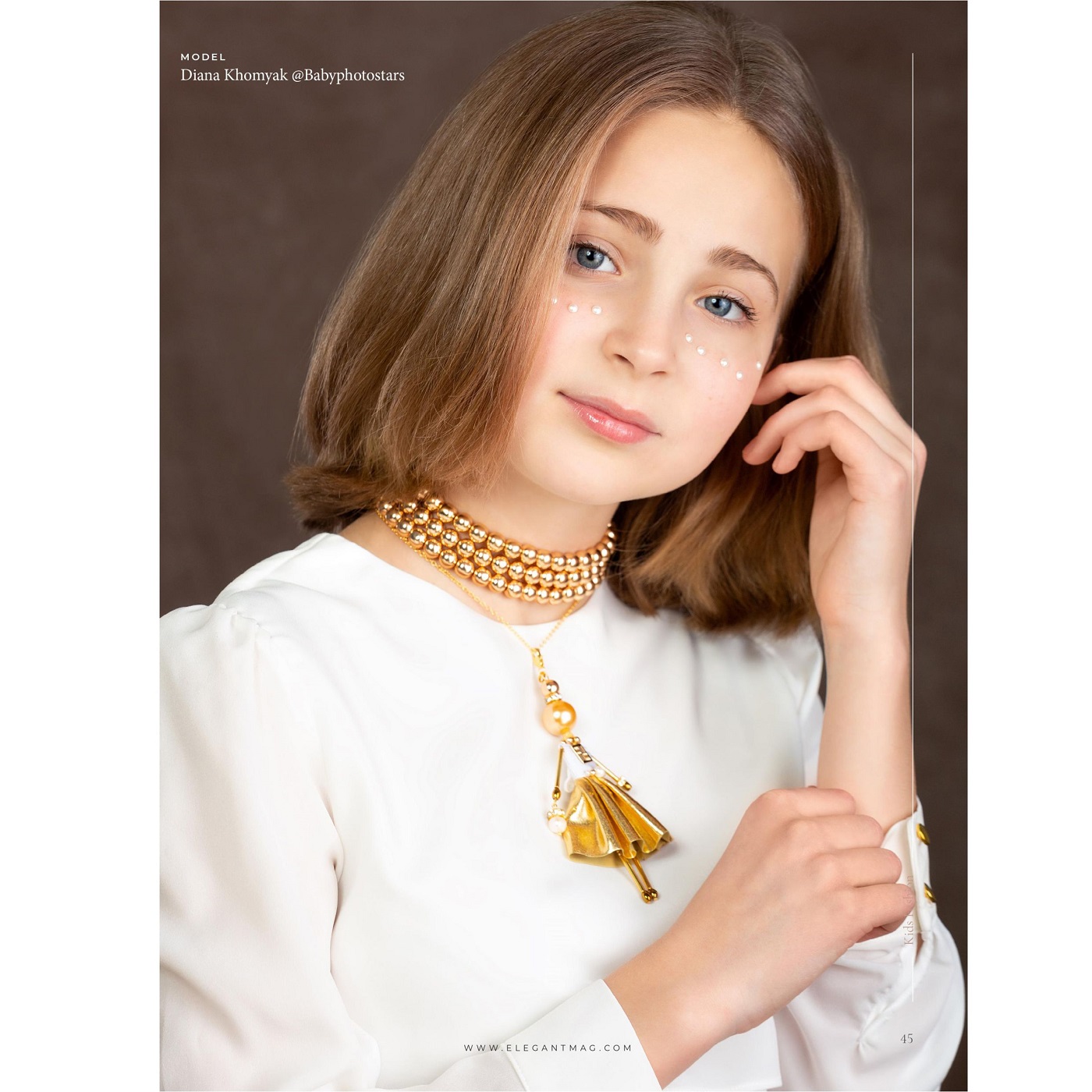 SARANA® doll pendant in a radiant gold outfit on a gold hematite necklace