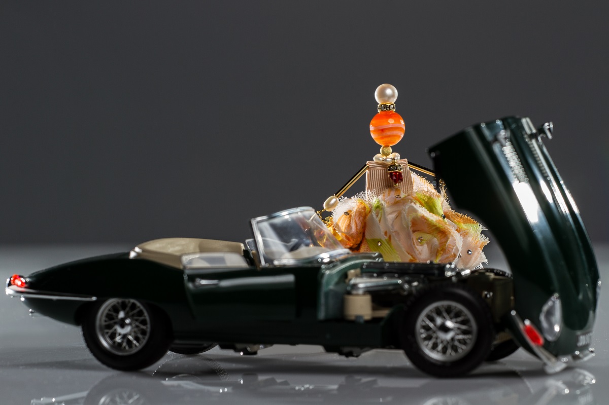 La muñeca-colgante «Milagro Pelirrojo» de SARANA® reparando su propio coche — una joya original